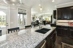 a kitchen with granite counter tops and black cabinets