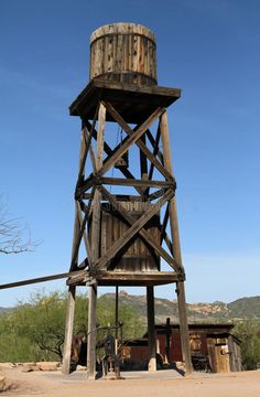 an old wooden water tower in the middle of nowhere