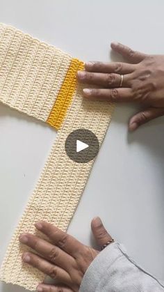 two hands are working on a knitted armband with the video title below it