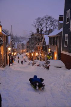 a snowboarder is going down a snowy street