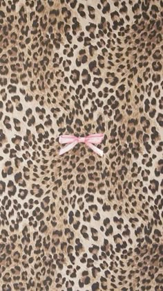 an animal print wallpaper with a pink bow on it