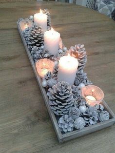 pine cones and candles are arranged on a tray