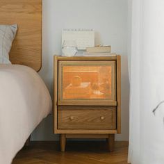 a bed with a wooden night stand next to it