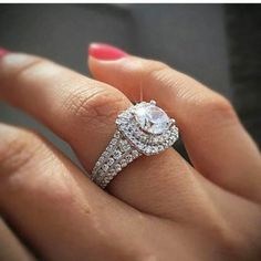 a close up of a person's hand with a diamond ring on their finger