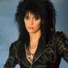 an image of a woman with black hair and piercings on her head wearing a leather jacket