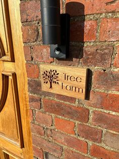 there is a sign that says tree farm on the brick wall next to a door