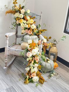 a rocking chair decorated with flowers and pumpkins