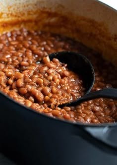 a pot full of beans with a spoon in it