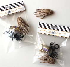 three bags filled with halloween decorations on top of a white table next to each other