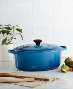 a blue casserole dish sitting on top of a counter next to some fruit