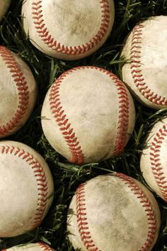 many baseballs are laying in the grass and ready to be used as wallpaper