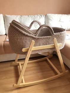 a crocheted baby's cradle in front of a couch