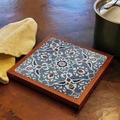 a wooden tray with a blue and white design on it next to a yellow towel