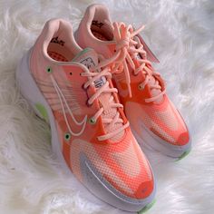 a pair of pink and green sneakers on white fur