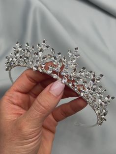 a woman's hand holding a crystal tiara