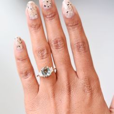 a woman's hand with a ring on it and an oval shaped diamond in the middle