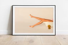 a framed photograph of a woman's legs and feet in a bathtub on the floor