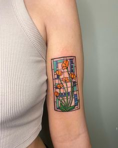 a woman's arm with a stained glass and flowers tattoo on the left inner arm