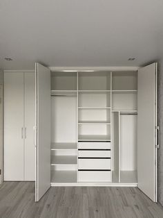 an empty room with white closets and wooden flooring on the walls is seen in this image