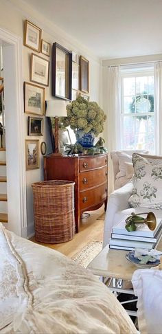 a living room filled with lots of furniture and pictures on the wall next to a window