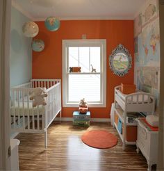 a baby's room with orange walls and white cribs