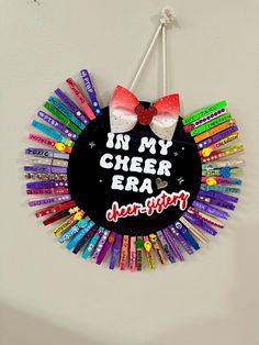 a circular sign that says in my cheer era surrounded by crayons