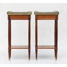 a pair of end tables with gold trimmings on the top and bottom shelf