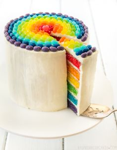 a rainbow cake with one slice cut out