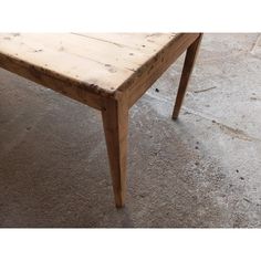 a wooden table sitting on top of a cement floor