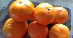 a pile of oranges sitting on top of a cutting board