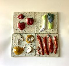 four different types of food arranged on small tiles