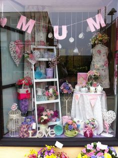 a window display with flowers and decorations in it