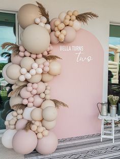 the balloon arch is made up of balloons and palm leaves, along with other decorations