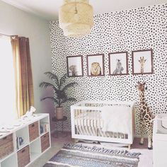 a baby's room with giraffes and zebra prints on the wall