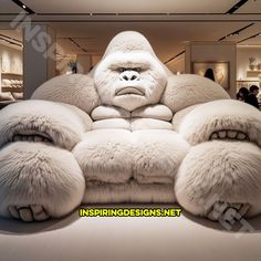 a big furry couch sitting in the middle of a room with people looking at it