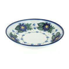 a blue and white bowl with flowers on the rim, sitting in front of a white background