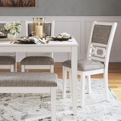 a dining room table and chairs with a rug on the floor