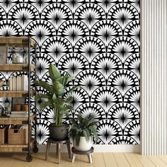 a black and white wallpaper with an intricate design in the middle, next to two potted plants