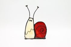 a glass figurine with a snail on it's back and a red heart in the middle