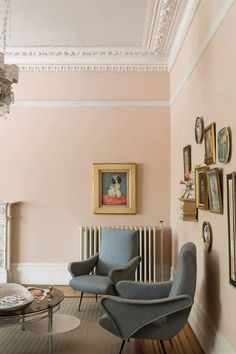 a living room filled with furniture and pictures on the wall next to a radiator