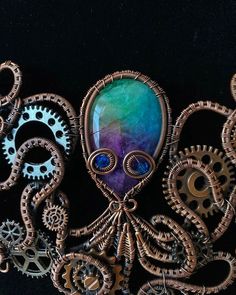 an octopus necklace with gears attached to it's back and the face is made out of copper wire