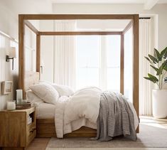 a bed with white linens and pillows in a bedroom next to a large window