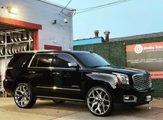 a black suv parked in front of a building