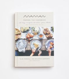 a cookbook on the cover of maman's cookbook, featuring plates and bowls filled with food