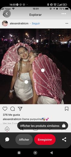 two girls in white dresses are hugging under an umbrella and smiling at the camera,