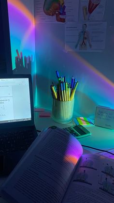 an open book sitting on top of a desk next to a laptop computer