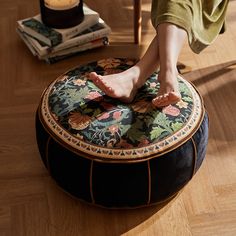 a person sitting on top of a round ottoman