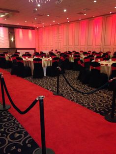 a banquet room set up with red and black linens, white tablecloths and chairs