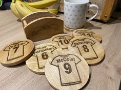 six wooden coasters with personalized shirts on them and a banana in the background