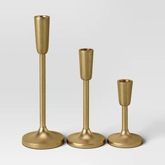 three gold candlesticks are standing next to each other